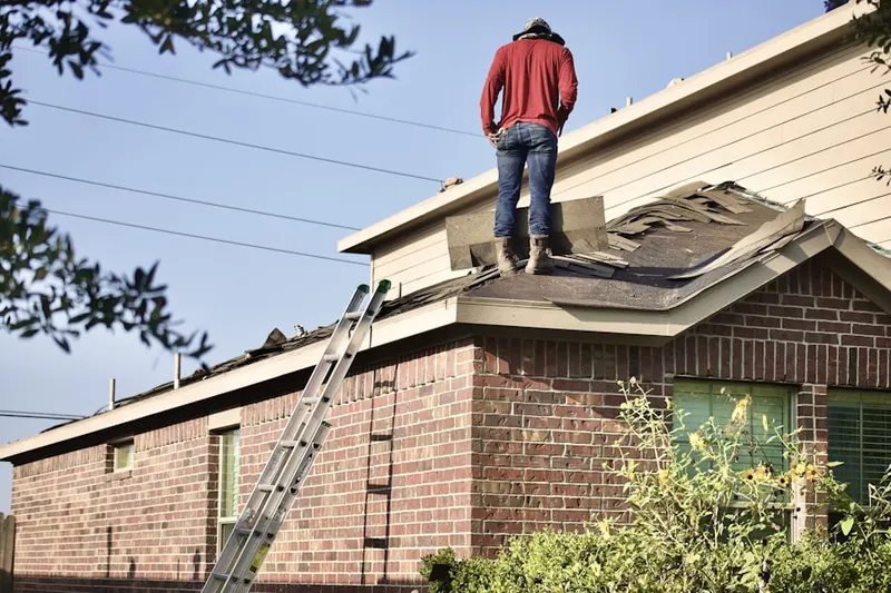 Professional roofer working on a residential roof in Jamaica Plain